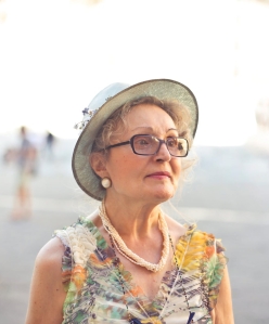 depth of field photography of woman in pastel color sleeveless shirt and white sunhat