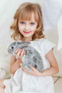smiling girl holding gray rabbit