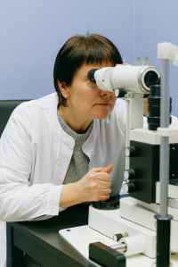 woman in white dress shirt using white microscope