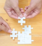 person holding white jigsaw puzzle piece